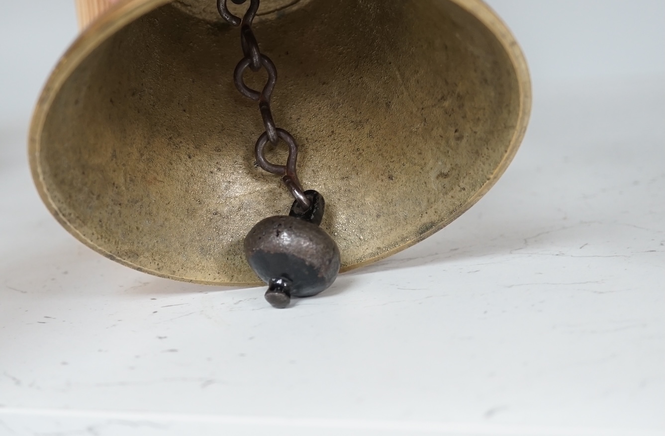 A late 19th/early 20th century brass school bell, with a turned mahogany handle, bell diameter 12.5cm, height 26cm. Condition - fair to good.